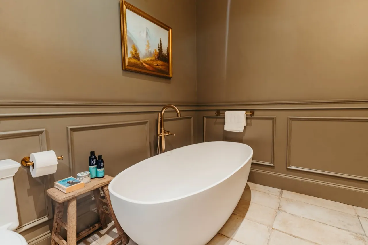 A calm, layered bathroom with a freestanding tub — English country textures brought home to the Carolinas